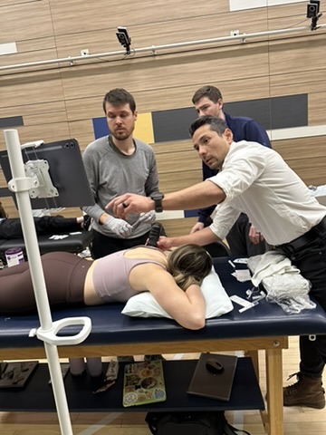 Carlos guiding a group of clinicians through hands-on ultrasound scanning